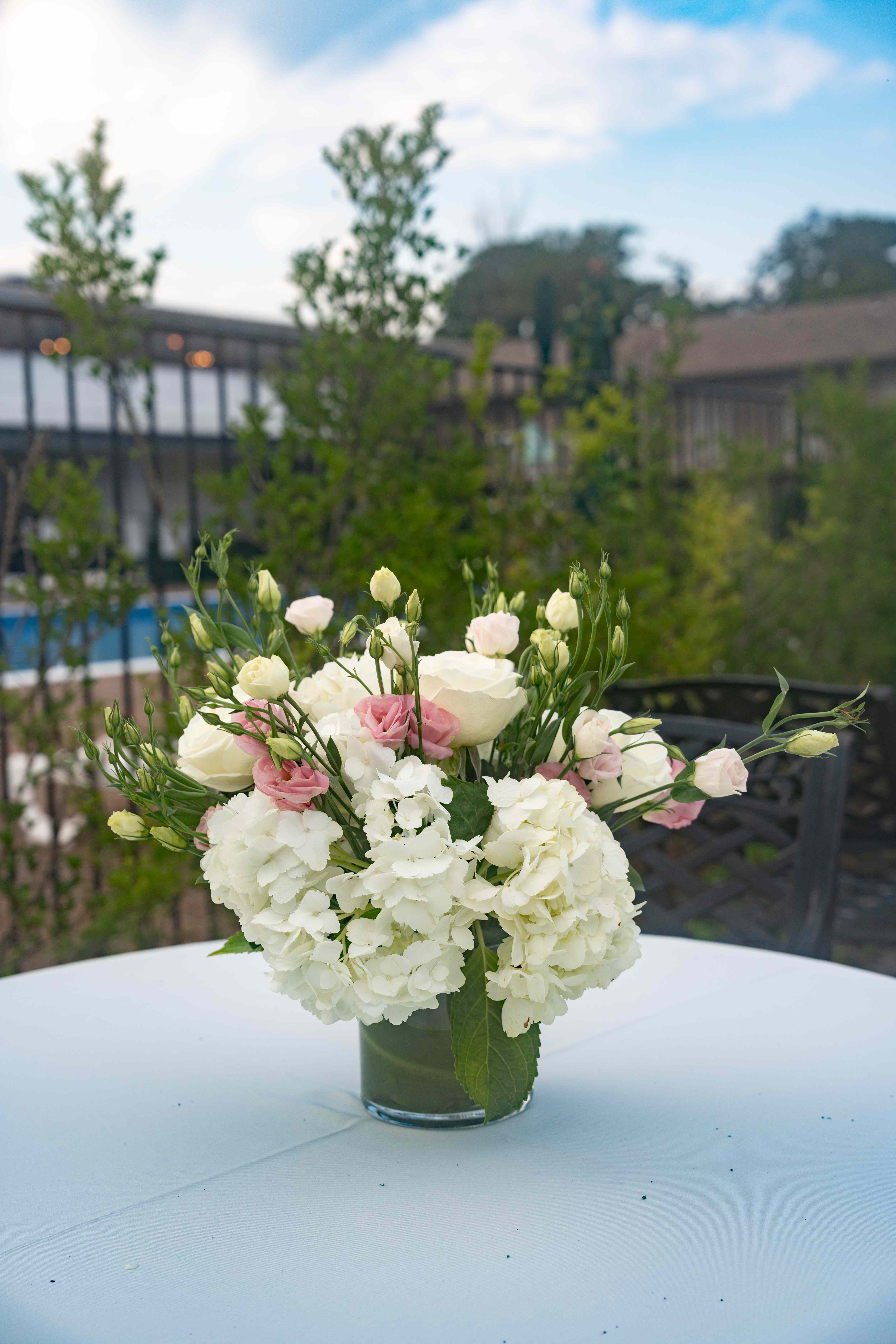 Elegant outdoor wedding centerpiece with white hydrangeas and pink roses