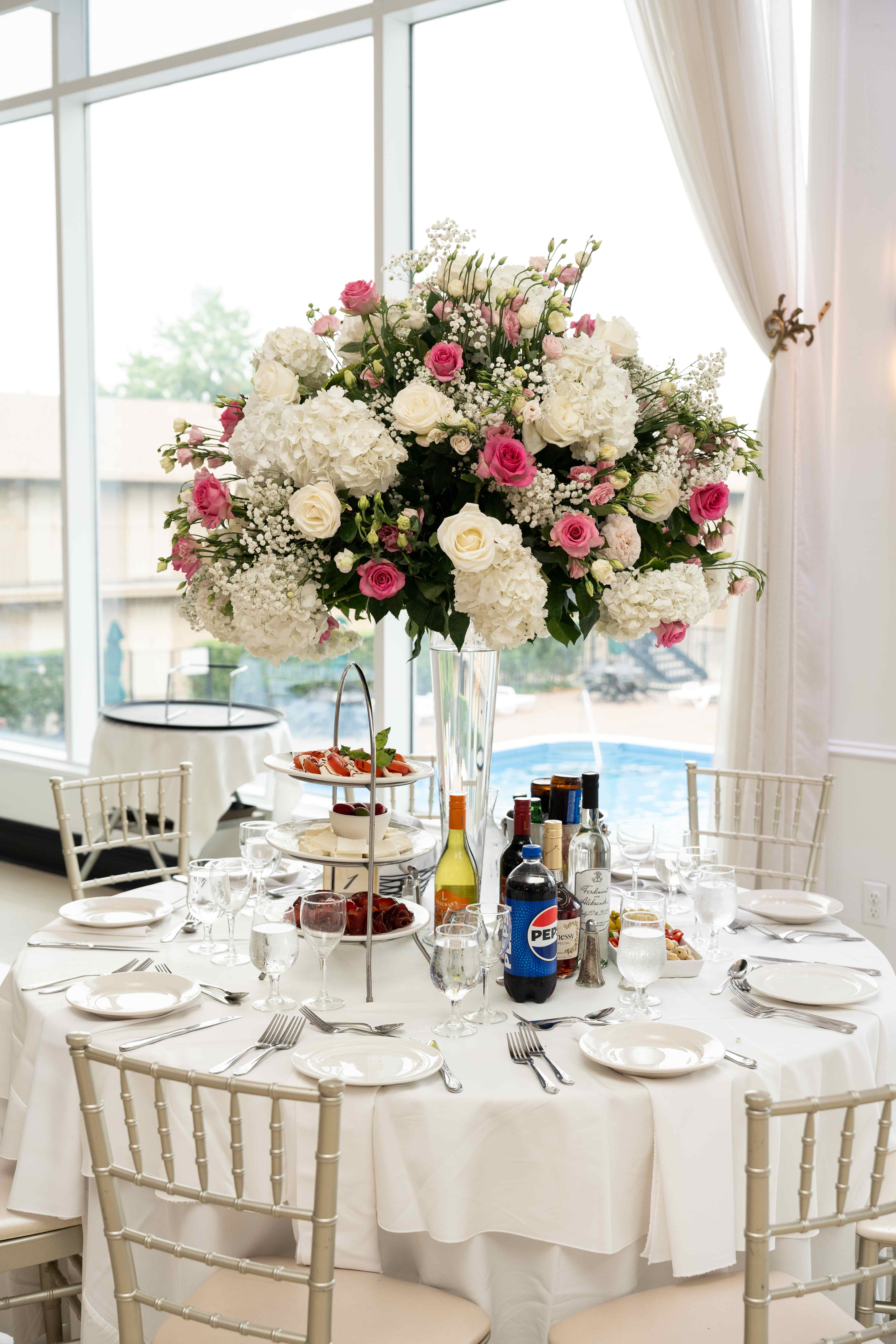 Dramatic tall wedding centerpiece with hydrangeas and roses on formal dining table